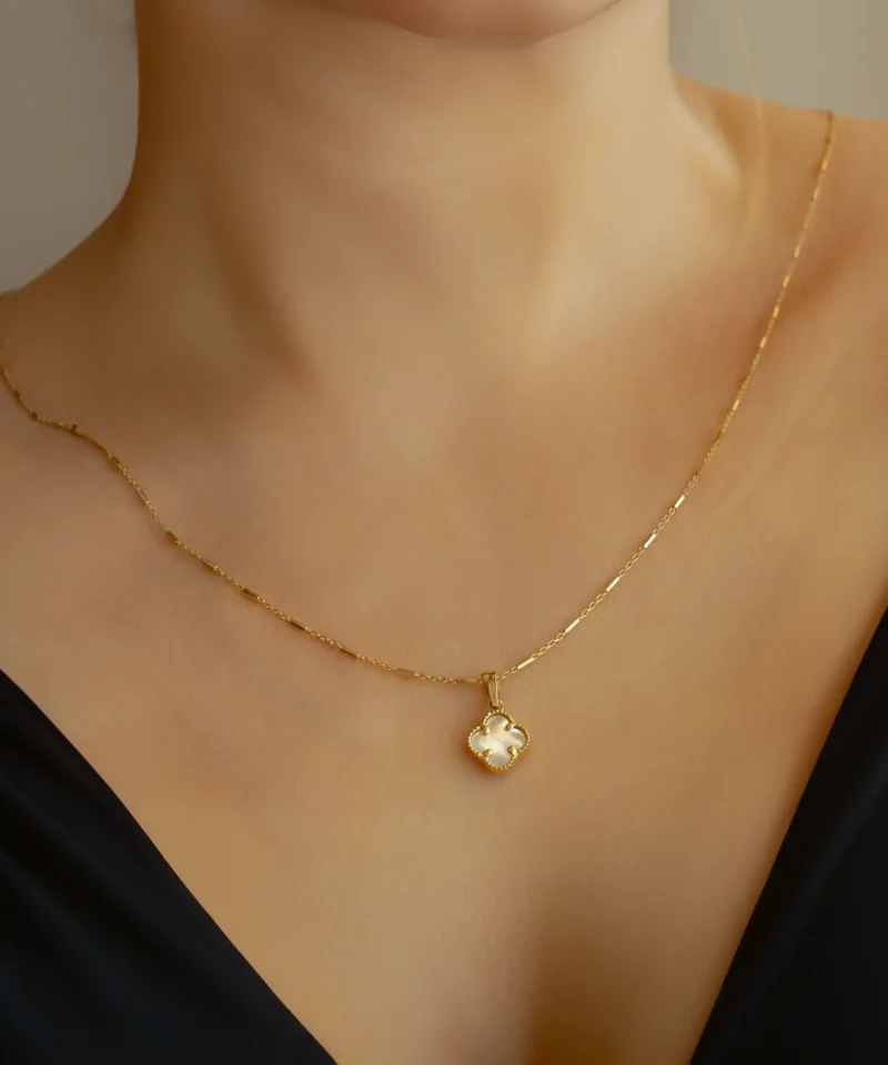 Złota zawieszka koniczynka z masą perłową - na szyi
