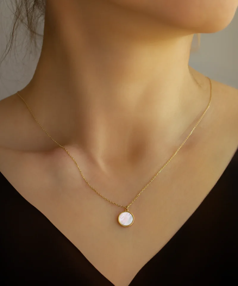 Złota celebrytka z masą perłową na szyi