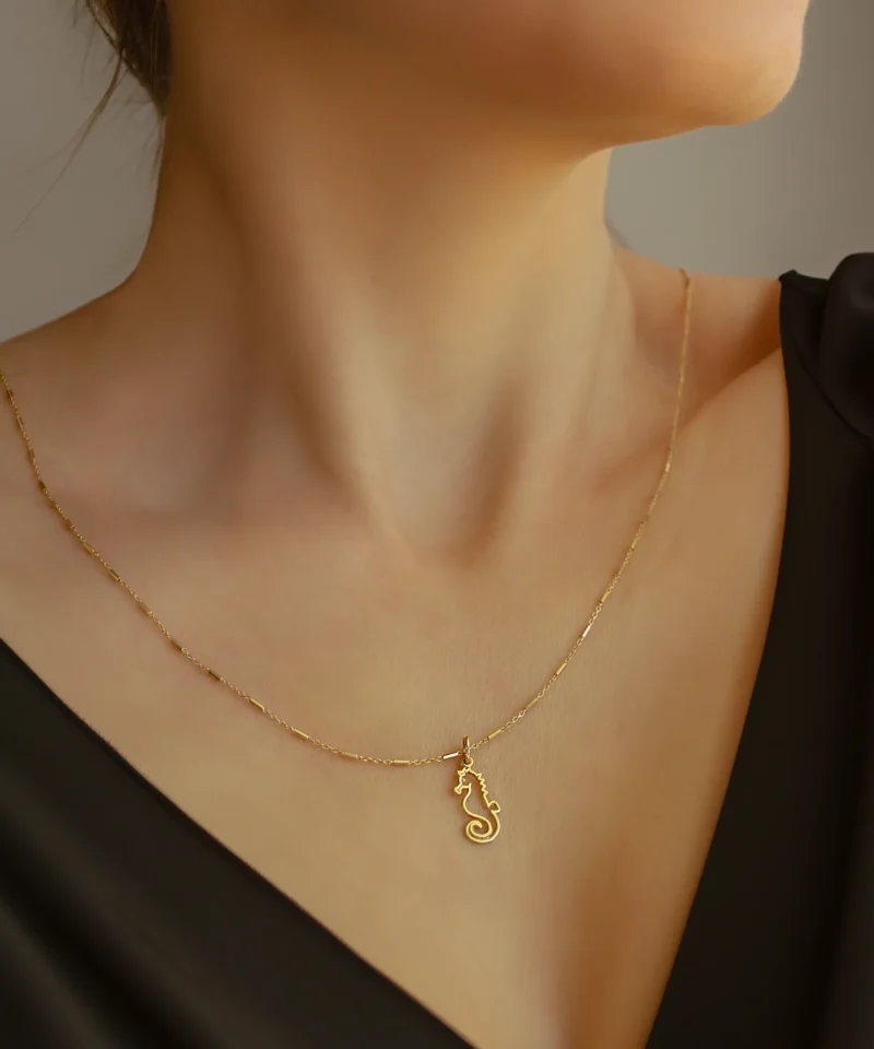Złoty wisiorek konik morski na szyi