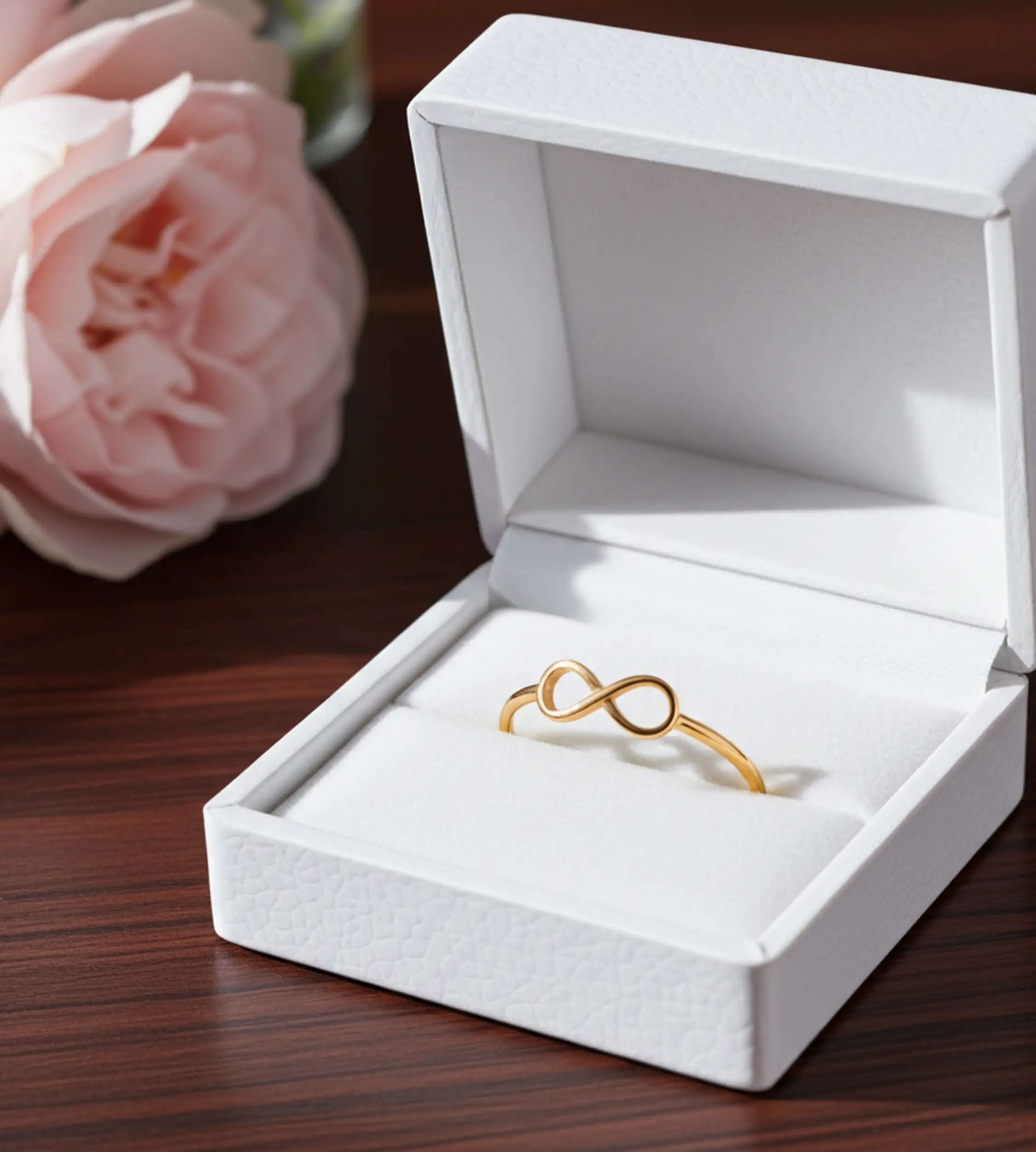 Złoty pierscionek z nieskończonością w białym opakowaniu jubilerskim