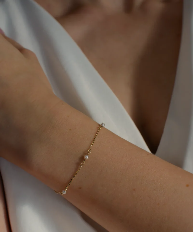 Delikatna złota bransoletka z 5 perłami słodkowodnymi 585 na nadgarstku