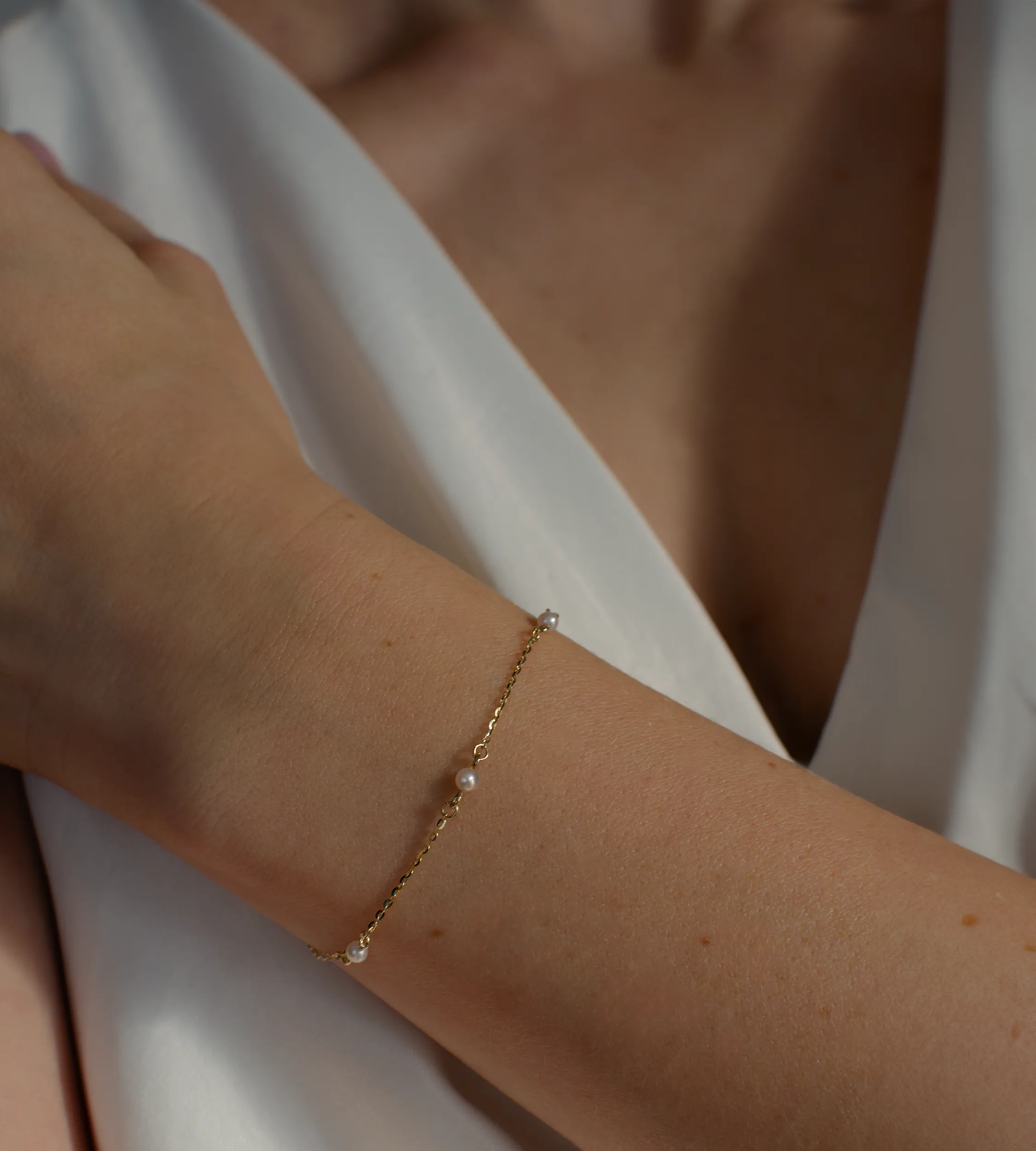 Delikatna złota bransoletka z 5 perłami słodkowodnymi 585 na nadgarstku