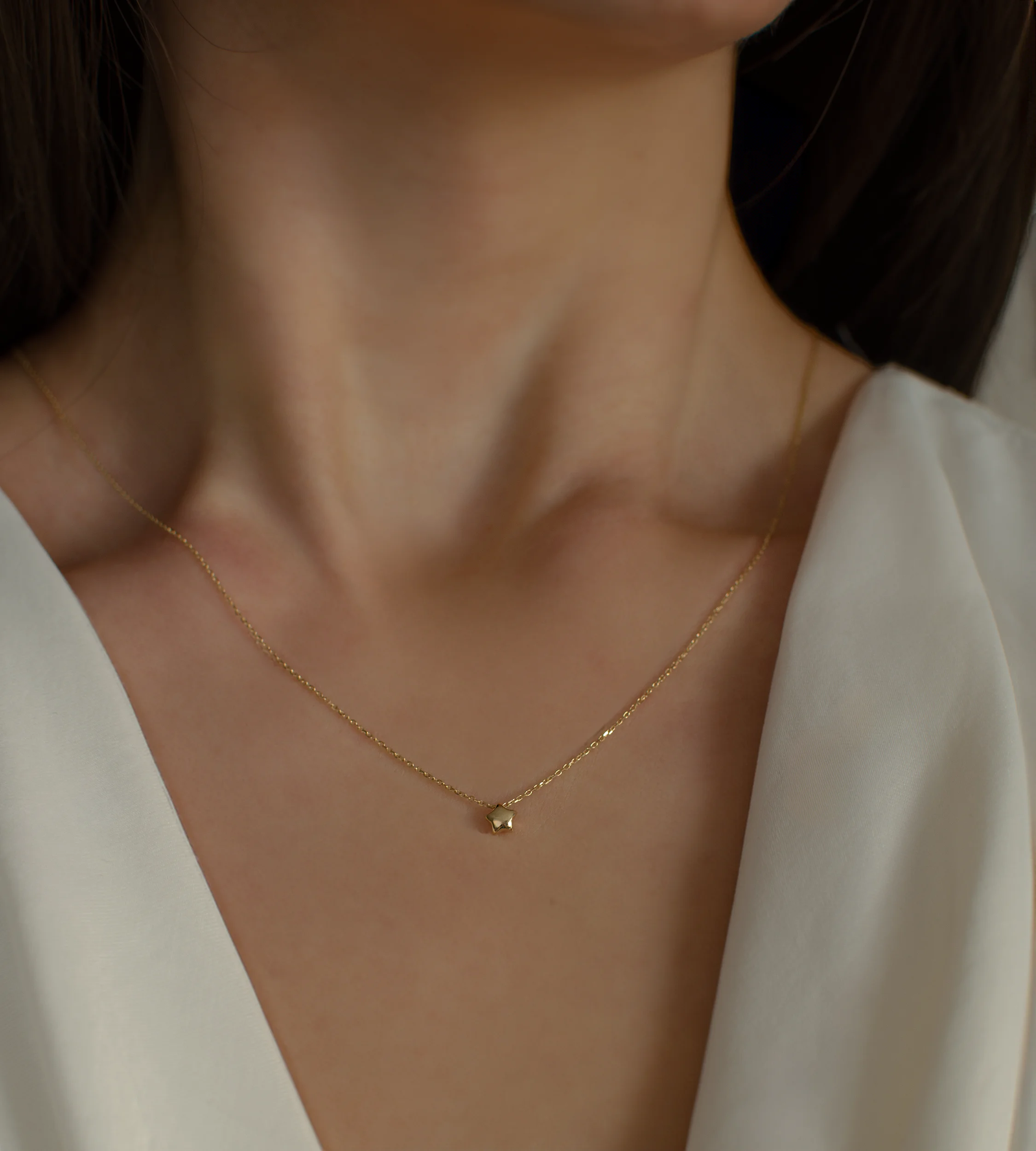 Delikatny złoty naszyjnik ankier z gwiazdką 585 na kobiecej szyi